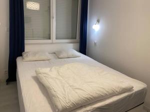 a bed with two pillows on it in a bedroom at La clairière Merlimont in Merlimont