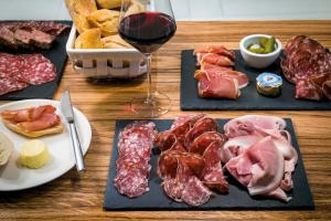 a table with three plates of meat and a glass of wine at Okko Hotels Cannes Centre in Cannes