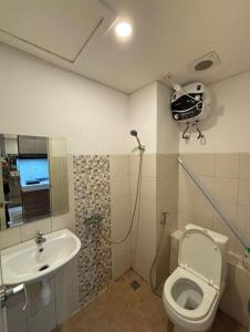 a bathroom with a toilet and a sink at Apartemen Riverview Tower Mahakam With Netflix By UVroomsOfficial in Tegalgede