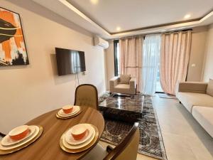 a living room with a table and a couch at Exquisite 1-Bedroom at Kololi Sands in Sere Kunda