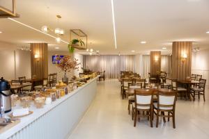 a restaurant with wooden tables and chairs and a bar at Arca's Hotel Umuarama in Umuarama
