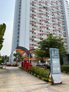 a sign in front of a large building at Apartemen Riverview Tower Mahakam With Netflix By UVroomsOfficial in Tegalgede