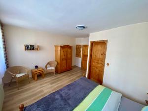 a bedroom with a bed and a table and chairs at Ferienwohnung GARTENBLICK im HAUS GERLACH in Walkenried