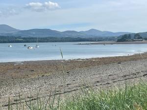a beach with boats in a body of water at 2,Tros yr Afon in Beaumaris