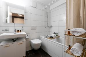 a white bathroom with a toilet and a sink at Spirit Apartments - Suite #4 - Zentral - Parkplatz in Brienz