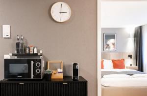 a bedroom with a tv and a clock on the wall at Spirit Apartments - Suite #4 - Zentral - Parkplatz in Brienz