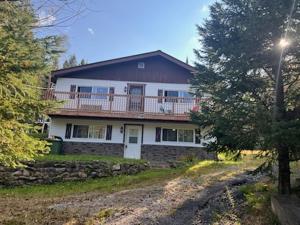 a large white house with a porch and a balcony at Maison de vacances in Rivière-Rouge