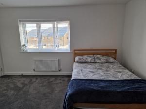 a bedroom with a bed and a window at Stratford Way House in Northfleet