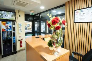 a vase of flowers sitting on a counter in an office at Hôtel de la Terrasse in Paris