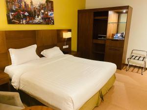 a bedroom with a large white bed in a room at Nawaress Hotel in Jazan