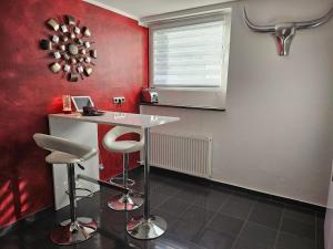eine Küche mit roten Wänden, einem Tisch und Stühlen in der Unterkunft Lounge 1 in Koblenz