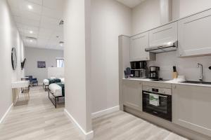 een keuken met witte kasten en een woonkamer bij Hyde Park Studios in Londen