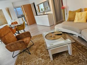 ein Wohnzimmer mit einer Couch und Stühlen und einem Tisch in der Unterkunft Lounge 1 in Koblenz