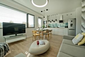 a living room with a couch and a tv and a table at Anchoria Prestige BlueApart Mechelinki in Mechelinki