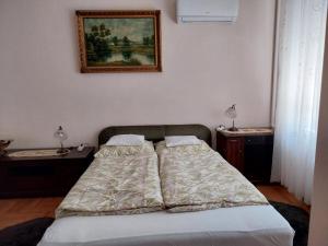 una camera da letto con due letti e un quadro sul muro di Mézeskalács vendégház a Balatonboglár