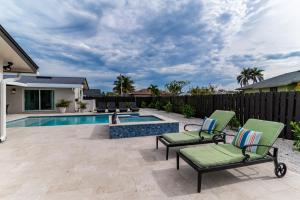 un patio con dos sillas y una piscina en New Listing Stunning 4 Bed I Heated Pool/Hot Tub, en Rookery Island