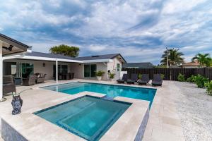 a swimming pool in the backyard of a house at New Listing I Stunning 4 Bed Home I Heated Pool & Hot Tub in Marco Island