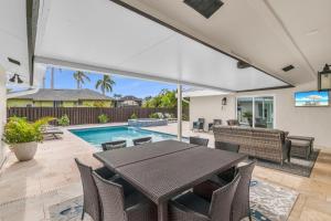 Un patio con mesa y sillas y una piscina. en New Listing Stunning 4 Bed I Heated Pool/Hot Tub, en Rookery Island