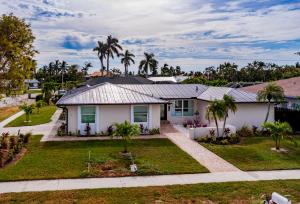 a white house with palm trees in a yard at New Listing I Stunning 4 Bed Home I Heated Pool & Hot Tub in Marco Island