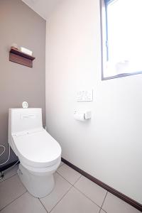 bagno bianco con servizi igienici e finestra di 屋根付き屋外ガス式BBQ ぐらんぱる公園シャボテン動物公園絶好立地貸別荘stella 星空眺望 遊具 ホームシアター 大画面任天堂スイッチ a Ito Altre 25 foto