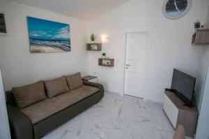 a living room with a couch and a flat screen tv at Apartments Sun Dance 2 with heated Pool in Novalja
