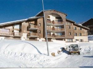 a building with a car parked in the snow at Appartement confortable 4 pers., proche pistes et commerces, parking, balcon Sud-Ouest, animaux admis - FR-1-733-91 in Crest-Voland