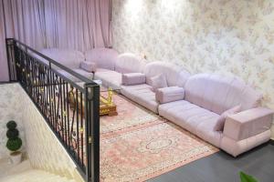 a living room with four white couches and a staircase at شقق زائر الشمال للشقق المخدومه in Sakakah +50 photos