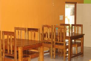 a dining room with a wooden table and chairs at Rose wood point in Chālsa Mahābāri