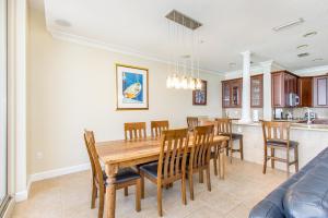a dining room and kitchen with a wooden table and chairs at Beach Club Gulf Front 3B Condo - 1602 in Pensacola Beach
