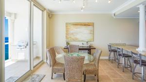 a dining room with a glass table and chairs at Beach Club Gulf Front 3B Condo - 1604 in Pensacola Beach