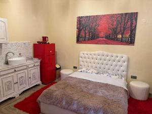 ein Schlafzimmer mit einem Bett, einem Waschbecken und einem Gemälde in der Unterkunft Emmanouil Pappas Studio in Serres