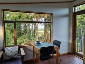 a room with a table and chairs and a large window at Oceanview at Brickfield in Hokitika