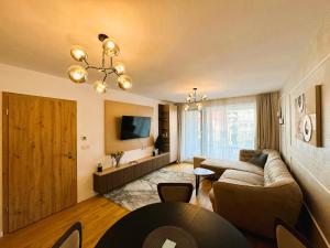 a living room with a couch and a tv at Chic Center Apartament in Braşov