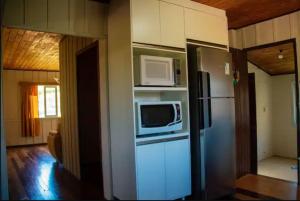 a kitchen with a refrigerator and a microwave at Casa Lar Azul in Rio Forcação