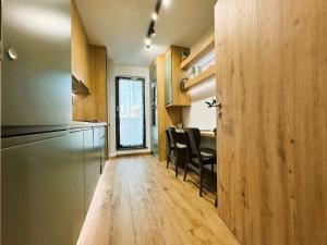 a kitchen with wooden cabinets and a table with chairs at Chic Center Apartament in Braşov +8 photos