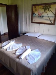 a bedroom with a bed with towels on it at Casa Lar Azul in Rio Forcação