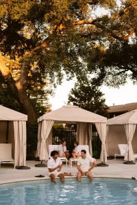 a group of people sitting around a swimming pool at Paso Robles Inn in Paso Robles