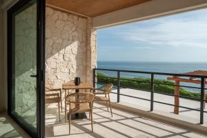 a balcony with a table and chairs and a view of the ocean at Sierra Mar in Isla Mujeres