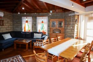 a living room with a table and a blue couch at Zhivka House in Glavatartsi
