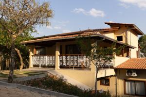 a house with a balcony with a fence at Pousada Nascentes do Paraíso in Vargem Bonita