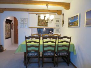 ein Esszimmer mit einem grünen Tisch und Stühlen in der Unterkunft Villa Franca U06 in Arosa