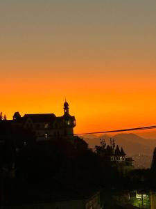 une silhouette d'un bâtiment avec un coucher de soleil en arrière-plan dans l'établissement Inn House Santa Teresa, à Rio de Janeiro