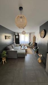 a living room with a couch and a table at Escapade Cambresienne in Cambrai