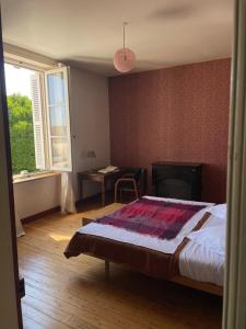 une chambre avec un lit, un bureau et une fenêtre dans l'établissement La Galotière, à Ingrandes-de-Touraine