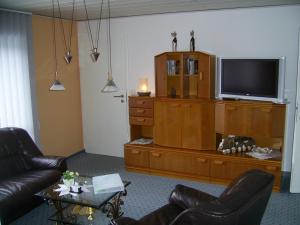 ein Wohnzimmer mit 2 Ledersesseln und einem TV in der Unterkunft Ferienwohnung Veronika Pape in Schmallenberg