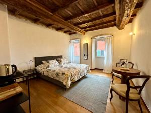 a bedroom with a bed and a table and a chair at Domagiho in Bedigliora