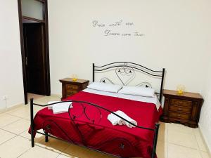 una camera da letto con un letto rosso con due asciugamani sopra di Maya Palace Real Rooms Palermo centre close to Cathedral a Palermo