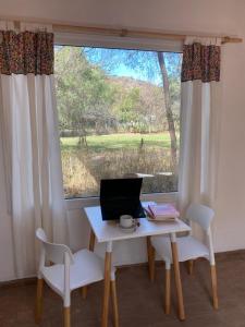 a desk with a laptop on it in front of a window at Casa Natu- Naturaleza in San Marcos Sierras