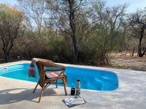 a chair and a bottle next to a swimming pool at Casa Natu- Naturaleza in San Marcos Sierras
