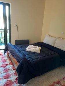 a bedroom with a bed with a blue blanket and a rug at Dimitris House in Pramanta
